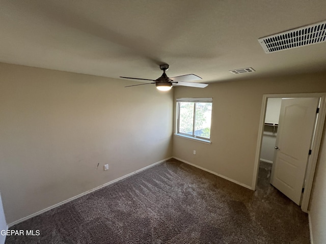 1160 Cielo Mar Dr, Socorro, TX 79927 - unfurnished bedroom featuring dark carpet, a ceiling fan, and a walk in closet