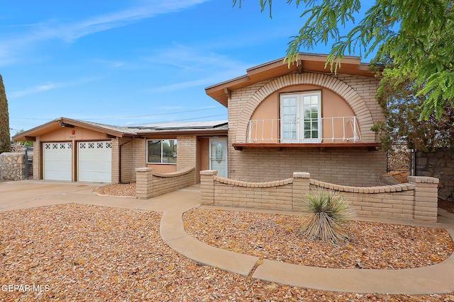2912 Chaswood St, El Paso, TX 79935 - view of front of home with brick siding, a garage, solar panels, and concrete driveway