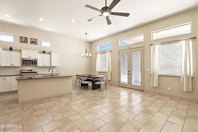 14512 Dominic Azcarate Dr, El Paso, TX 79938 - kitchen with stainless steel appliances, decorative backsplash, a chandelier, white cabinetry, and a ceiling fan