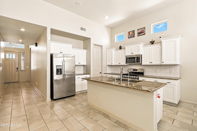 14512 Dominic Azcarate Dr, El Paso, TX 79938 - kitchen featuring stainless steel appliances, backsplash, a high ceiling, dark stone countertops, and white cabinets