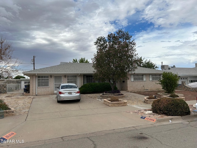 10309 Woodruff Ct, El Paso, TX 79925 - view of front facade with brick siding, concrete driveway, and a shingled roof