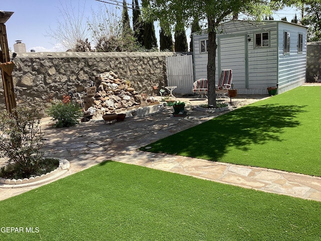 10309 Woodruff Ct, El Paso, TX 79925 - view of green lawn featuring a storage unit and a patio