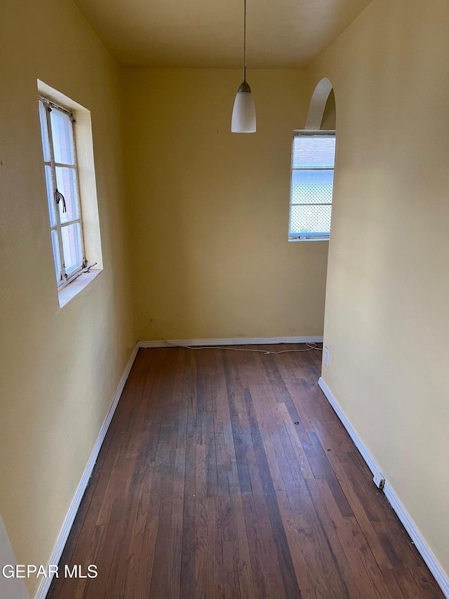 1118 N Laurel St, El Paso, TX 79902 - unfurnished dining area with arched walkways, dark wood-type flooring, and healthy amount of natural light