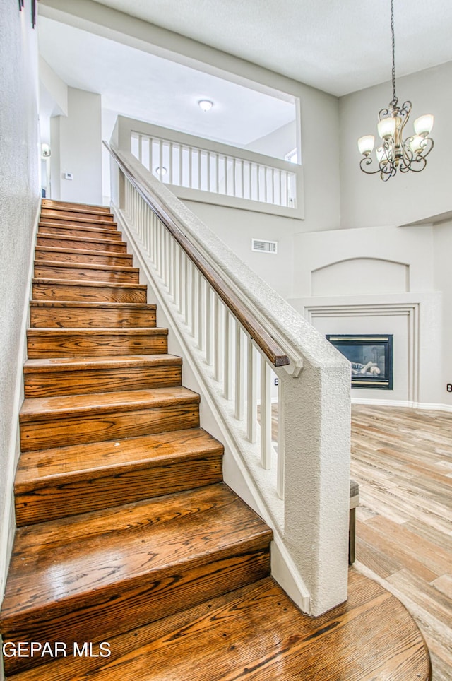 11813 Deer Grass Cir, El Paso, TX 79936 - staircase featuring a chandelier and wood finished floors
