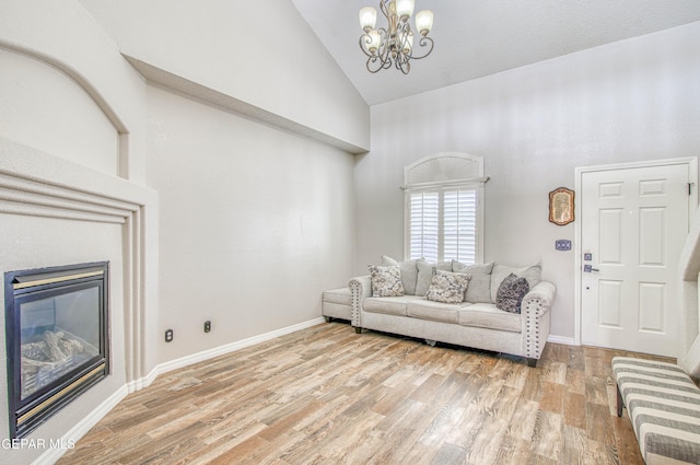 11813 Deer Grass Cir, El Paso, TX 79936 - living area with high vaulted ceiling, a chandelier, a glass covered fireplace, and light wood-type flooring