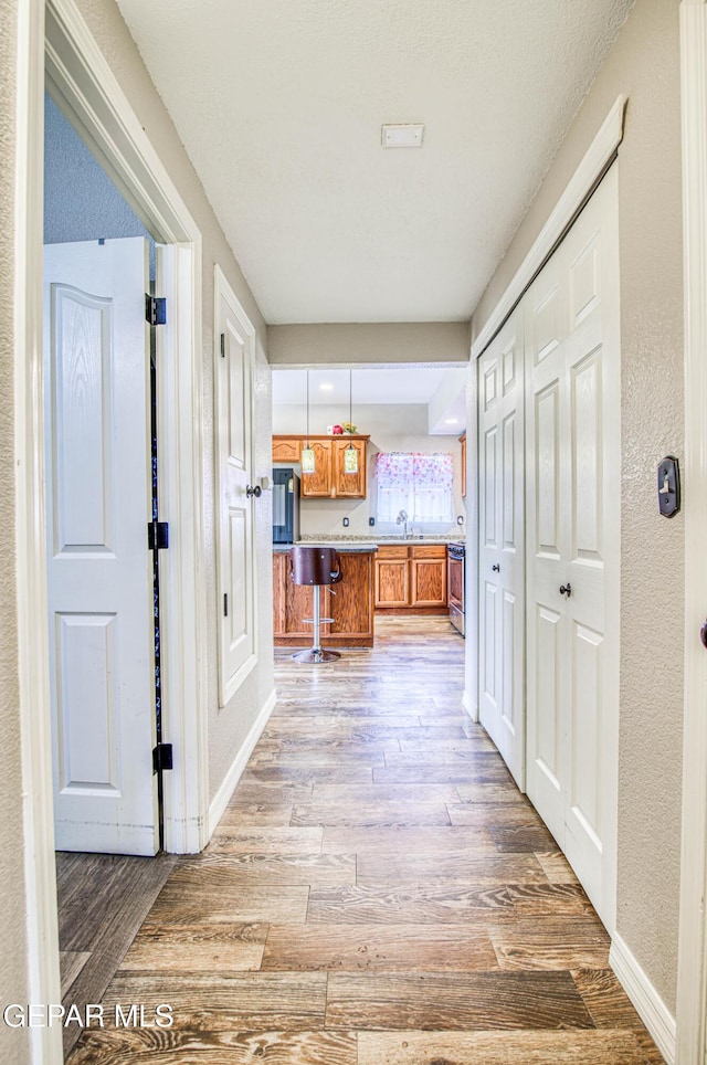 11813 Deer Grass Cir, El Paso, TX 79936 - corridor with light wood-style floors and a textured wall