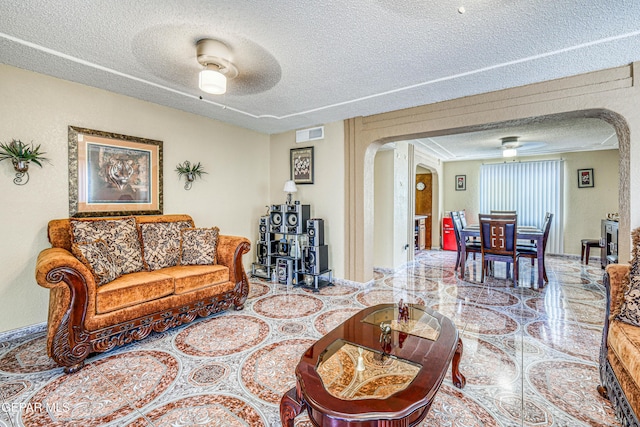 11581 Valle Verde Rd, Socorro, TX 79927 - living area with arched walkways, ceiling fan, and a textured ceiling