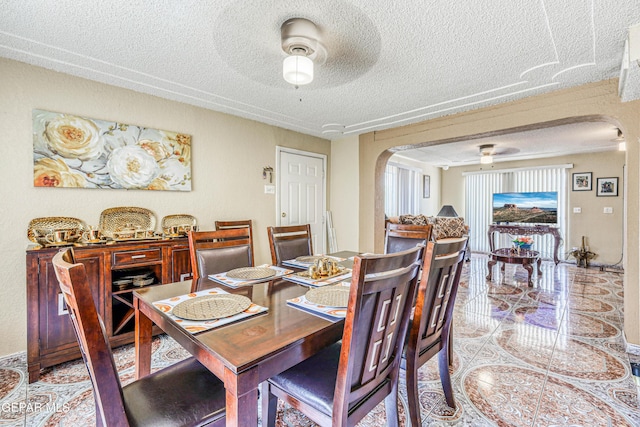 11581 Valle Verde Rd, Socorro, TX 79927 - dining room with arched walkways, a textured ceiling, light tile patterned floors, and ceiling fan