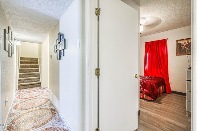 11581 Valle Verde Rd, Socorro, TX 79927 - corridor with a textured ceiling, wood finished floors, and stairs