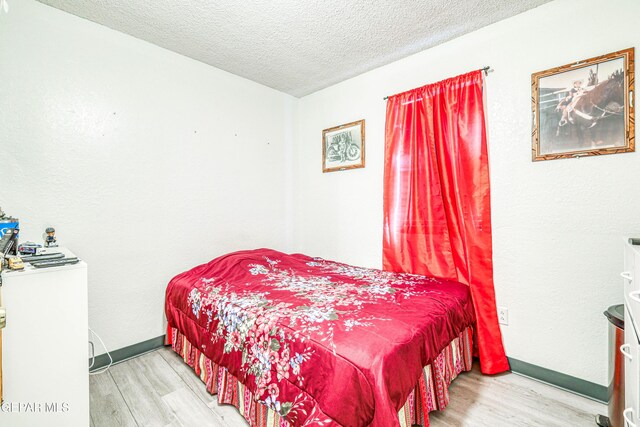 11581 Valle Verde Rd, Socorro, TX 79927 - bedroom with wood finished floors and a textured ceiling