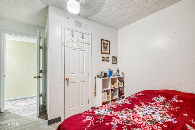 11581 Valle Verde Rd, Socorro, TX 79927 - bedroom with a textured ceiling, wood finished floors, a textured wall, and a ceiling fan