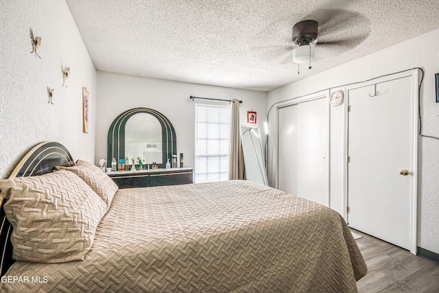 11581 Valle Verde Rd, Socorro, TX 79927 - bedroom featuring wood finished floors, a textured ceiling, a textured wall, a ceiling fan, and a closet