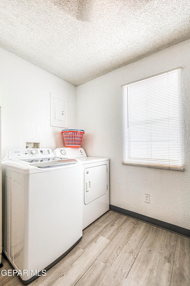 11581 Valle Verde Rd, Socorro, TX 79927 - laundry area with washing machine and dryer, light wood-style flooring, and a textured ceiling