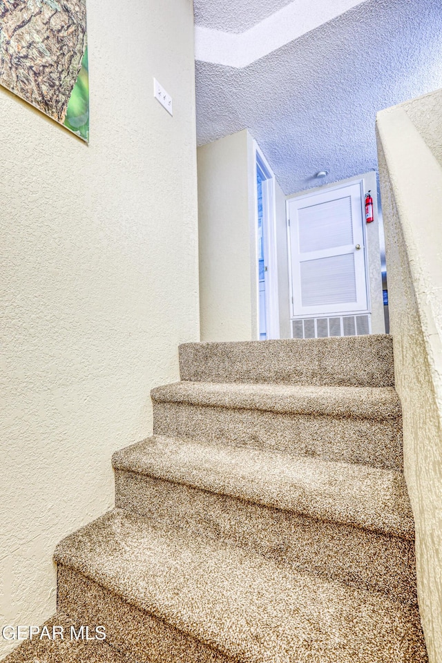 11581 Valle Verde Rd, Socorro, TX 79927 - staircase with a textured wall and a textured ceiling