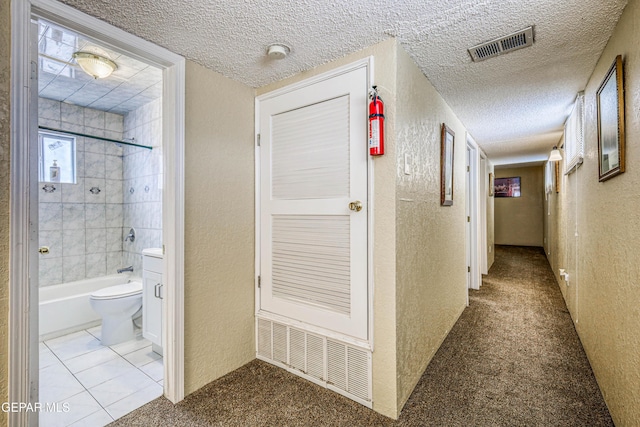 11581 Valle Verde Rd, Socorro, TX 79927 - hallway featuring a textured wall, a textured ceiling, carpet, and tile patterned floors