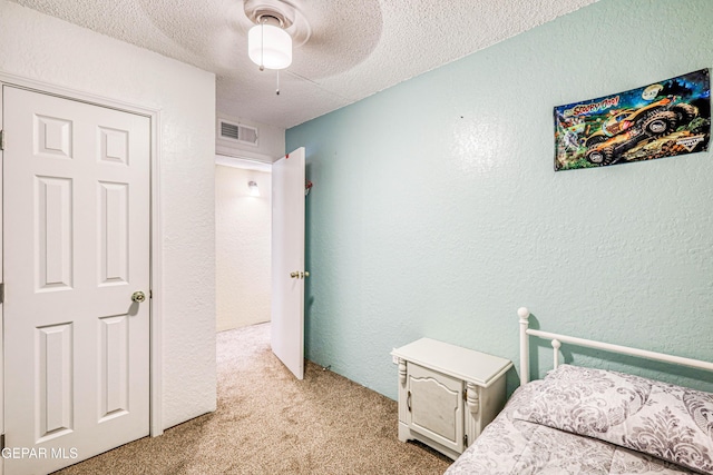 11581 Valle Verde Rd, Socorro, TX 79927 - bedroom with light carpet, a textured wall, a textured ceiling, and ceiling fan