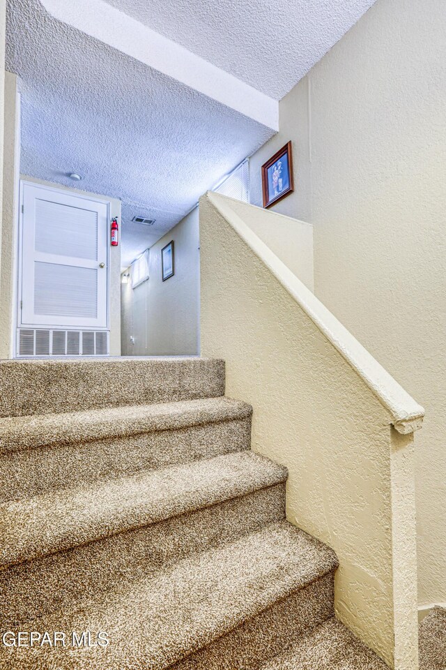 11581 Valle Verde Rd, Socorro, TX 79927 - stairway with a textured wall and a textured ceiling