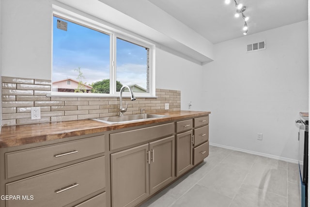 205 Caribe Cir, El Paso, TX 79927 - kitchen featuring butcher block counters, tasteful backsplash, light tile patterned flooring, and rail lighting