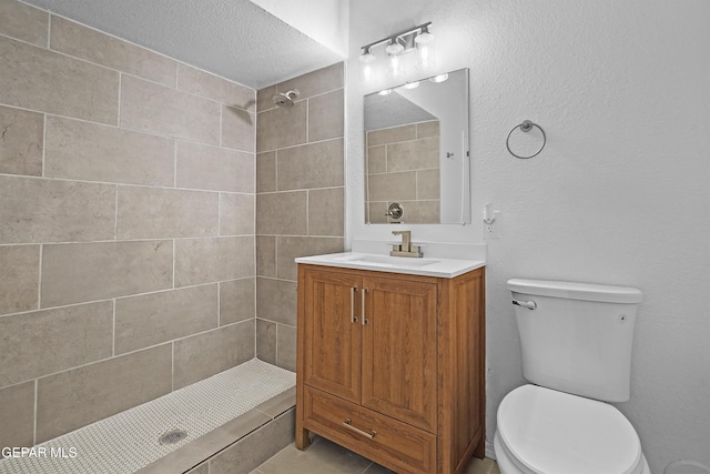 205 Caribe Cir, El Paso, TX 79927 - bathroom featuring a tile shower, vanity, and a textured ceiling