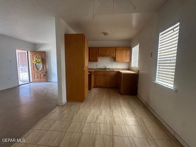 1137 Cimarron St, El Paso, TX 79915 - kitchen featuring brown cabinetry, light countertops, and light floors
