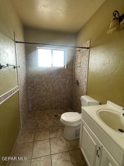 1137 Cimarron St, El Paso, TX 79915 - bathroom featuring tiled shower, vanity, and tile patterned floors