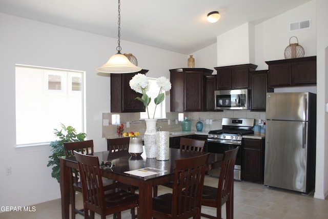 1374 Gusart Ave, El Paso, TX 79928 - kitchen with appliances with stainless steel finishes, dark brown cabinetry, light countertops, decorative backsplash, and vaulted ceiling