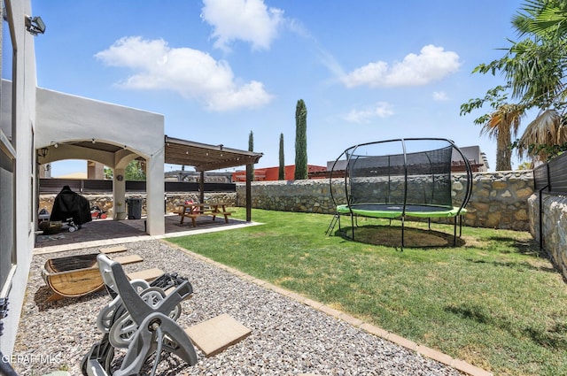 14516 Jesus Almeida, El Paso, TX 79938 - fenced backyard featuring a trampoline and a patio area