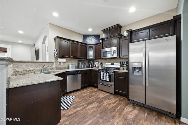 14516 Jesus Almeida, El Paso, TX 79938 - kitchen featuring appliances with stainless steel finishes, dark brown cabinetry, decorative backsplash, dark wood-style floors, and recessed lighting