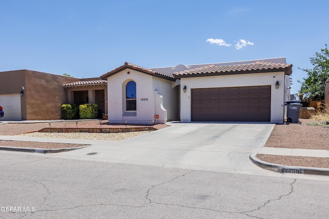 14516 Jesus Almeida, El Paso, TX 79938 - mediterranean / spanish house with driveway, an attached garage, stucco siding, and a tile roof