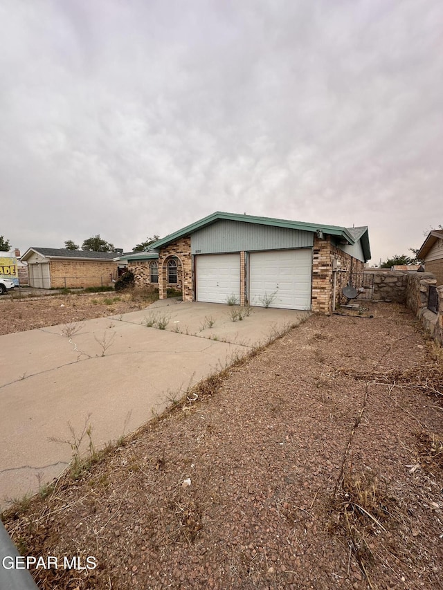 10428 Cronus Dr, El Paso, TX 79924 - view of front of house with driveway, an attached garage, and brick siding