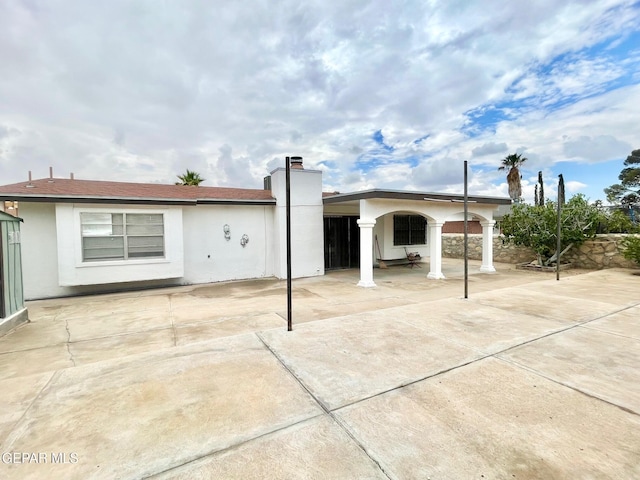 1611 James Chisum Dr, El Paso, TX 79936 - back of property with a chimney, stucco siding, and a patio area
