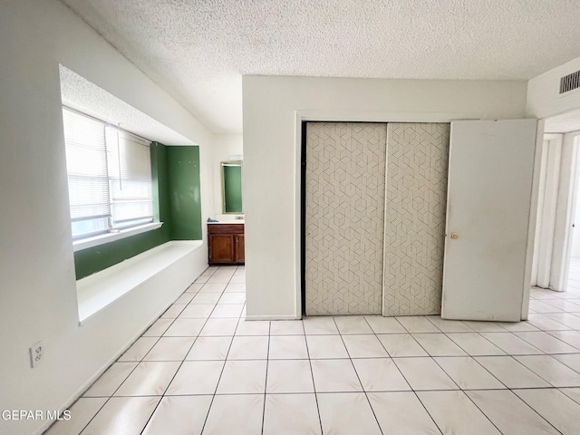 1611 James Chisum Dr, El Paso, TX 79936 - unfurnished bedroom with a textured ceiling, a closet, and light tile patterned floors