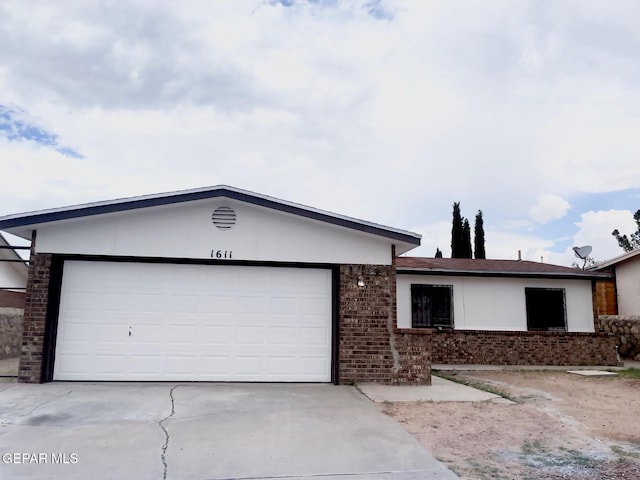 1611 James Chisum Dr, El Paso, TX 79936 - ranch-style home featuring a garage, brick siding, and driveway