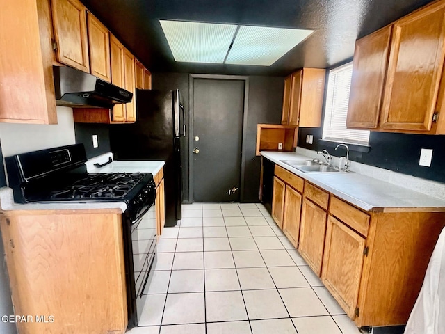 1611 James Chisum Dr, El Paso, TX 79936 - kitchen featuring black gas range oven, under cabinet range hood, light countertops, light tile patterned flooring, and brown cabinetry
