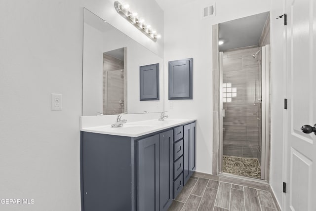 2301 Tony Harper St, El Paso, TX 79938 - bathroom with a shower stall, double vanity, and wood finish floors