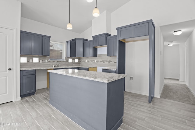 2301 Tony Harper St, El Paso, TX 79938 - kitchen featuring wood tiled floors, decorative backsplash, a kitchen island, hanging light fixtures, and high vaulted ceiling