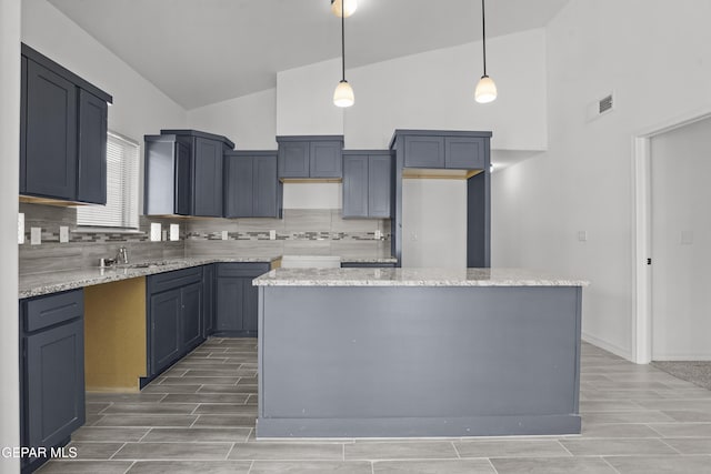 2301 Tony Harper St, El Paso, TX 79938 - kitchen with high vaulted ceiling, wood tiled floors, tasteful backsplash, a kitchen island, and hanging light fixtures