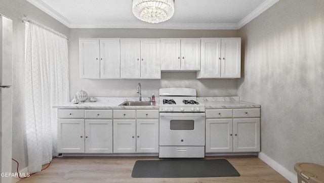 2123 Magoffin Ave, El Paso, TX 79901 - kitchen featuring white gas range, ornamental molding, light wood finished floors, light countertops, and a chandelier