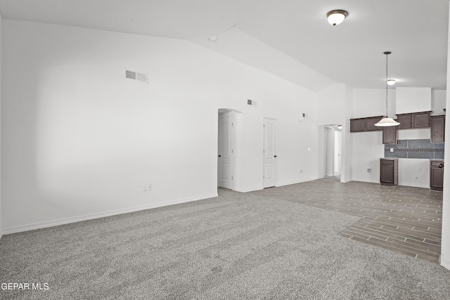 14325 Toby Davis Dr, Horizon City, TX 79928 - unfurnished living room featuring high vaulted ceiling, arched walkways, and carpet floors