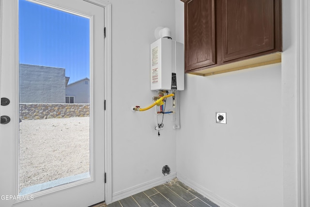 14325 Toby Davis Dr, Horizon City, TX 79928 - laundry room featuring cabinet space, hookup for an electric dryer, water heater, and dark wood-style flooring