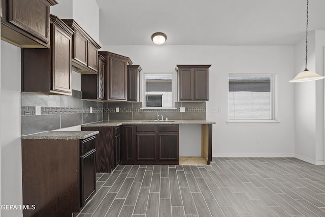 14325 Toby Davis Dr, Horizon City, TX 79928 - kitchen with dark brown cabinetry, tasteful backsplash, hanging light fixtures, and wood finished floors