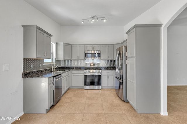 14304 Woods Point Ave, El Paso, TX 79938 - kitchen with stainless steel appliances, gray cabinetry, dark stone countertops, and decorative backsplash