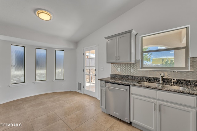 14304 Woods Point Ave, El Paso, TX 79938 - kitchen with stainless steel dishwasher, vaulted ceiling, decorative backsplash, healthy amount of natural light, and dark stone countertops