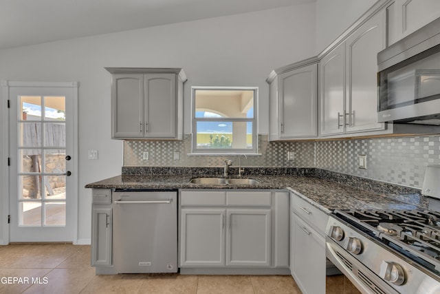 14304 Woods Point Ave, El Paso, TX 79938 - kitchen featuring appliances with stainless steel finishes, lofted ceiling, backsplash, dark stone counters, and plenty of natural light