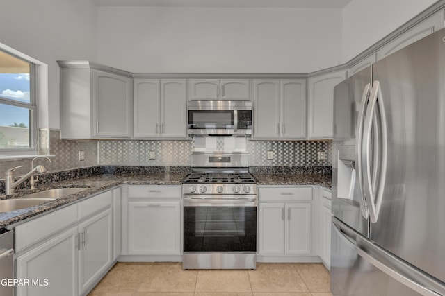 14304 Woods Point Ave, El Paso, TX 79938 - kitchen with appliances with stainless steel finishes, dark stone counters, tasteful backsplash, and light tile patterned flooring