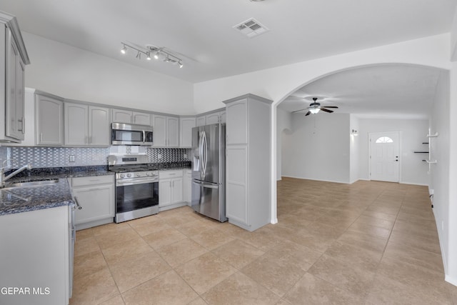 14304 Woods Point Ave, El Paso, TX 79938 - kitchen featuring appliances with stainless steel finishes, arched walkways, a ceiling fan, gray cabinetry, and backsplash