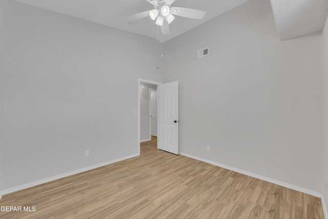 14304 Woods Point Ave, El Paso, TX 79938 - spare room featuring ceiling fan, light wood-style flooring, and a towering ceiling