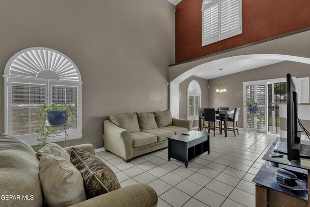 12372 Robert Dahl Dr, El Paso, TX 79938 - living area with arched walkways, a chandelier, a towering ceiling, and light tile patterned floors