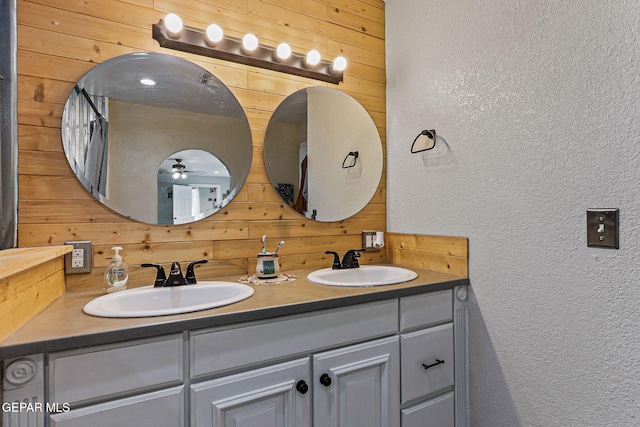 1624 Vinton Rd, Anthony, NM 88021 - full bathroom with wood walls, double vanity, a textured wall, and a ceiling fan