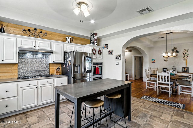 1624 Vinton Rd, Anthony, NM 88021 - kitchen featuring appliances with stainless steel finishes, under cabinet range hood, arched walkways, ceiling fan, and a chandelier